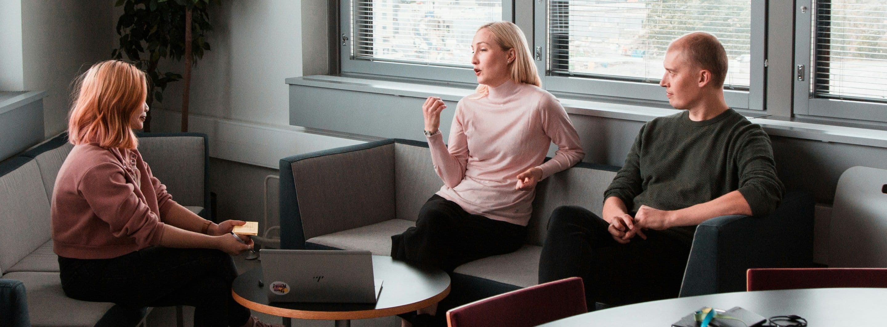 A bright open-plan office with people working along rows of desks
