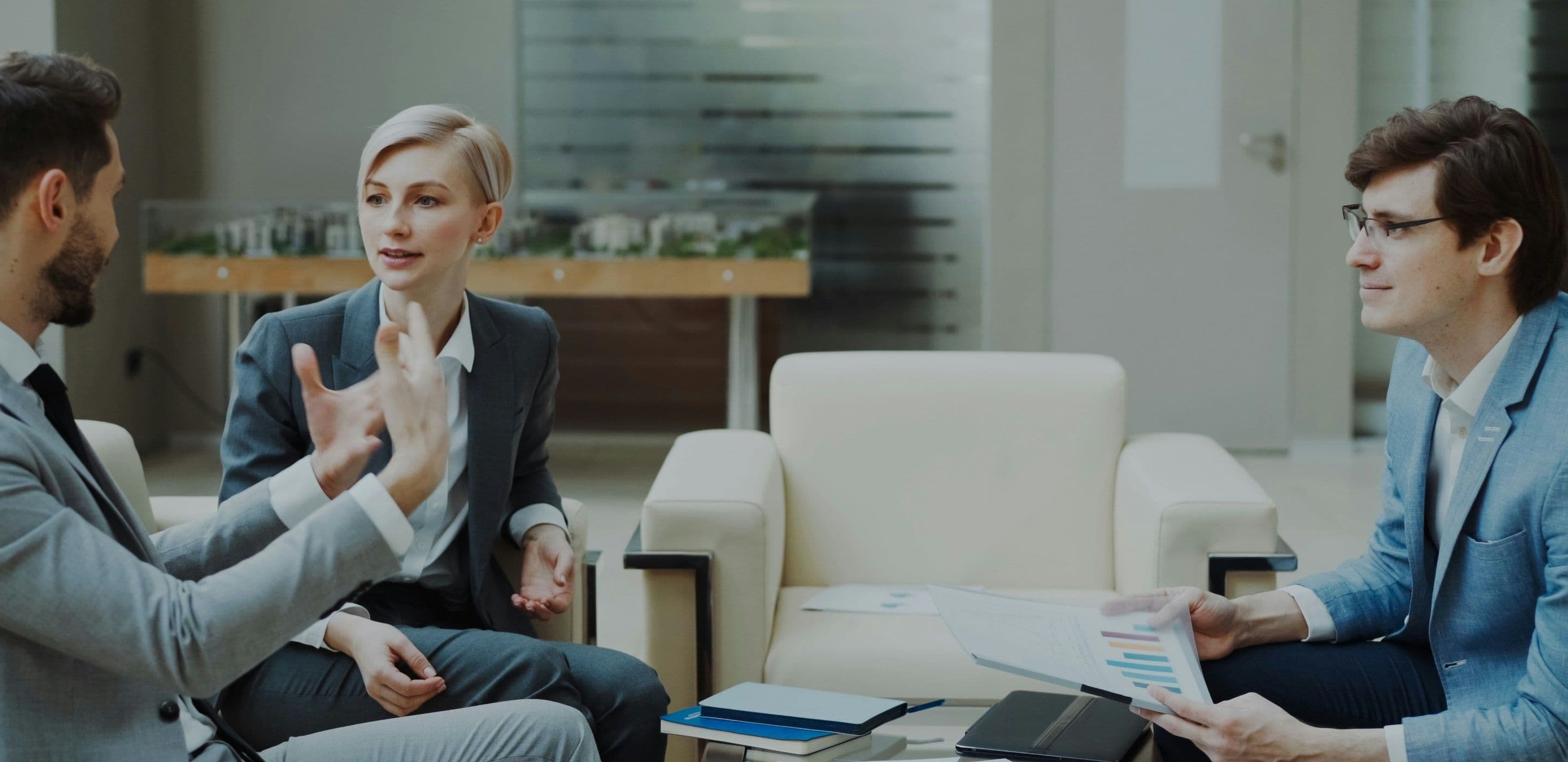 Three colleagues in discussion in an office lounge